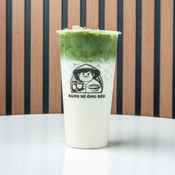 A Banh Mi Ong Beo branded drink with a white base and green matcha topping.